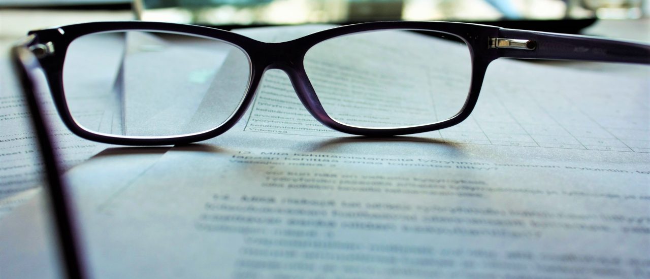 eyeglasses resting on a piece of office paper